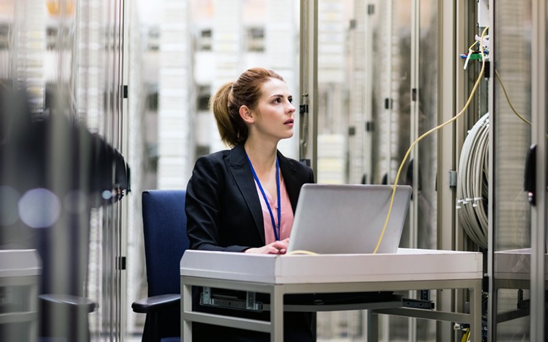 IT technician surveying servers in data center