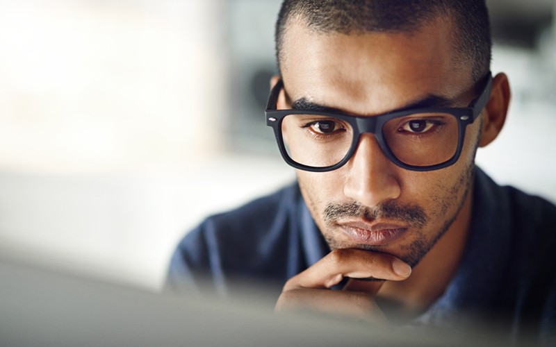 Smiling man looking at desktop monitor