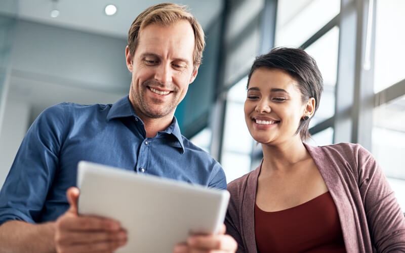 Man and woman collaborating over tablet