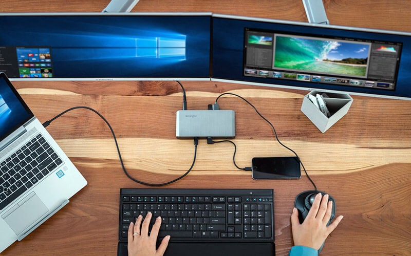 Person using two monitors at work