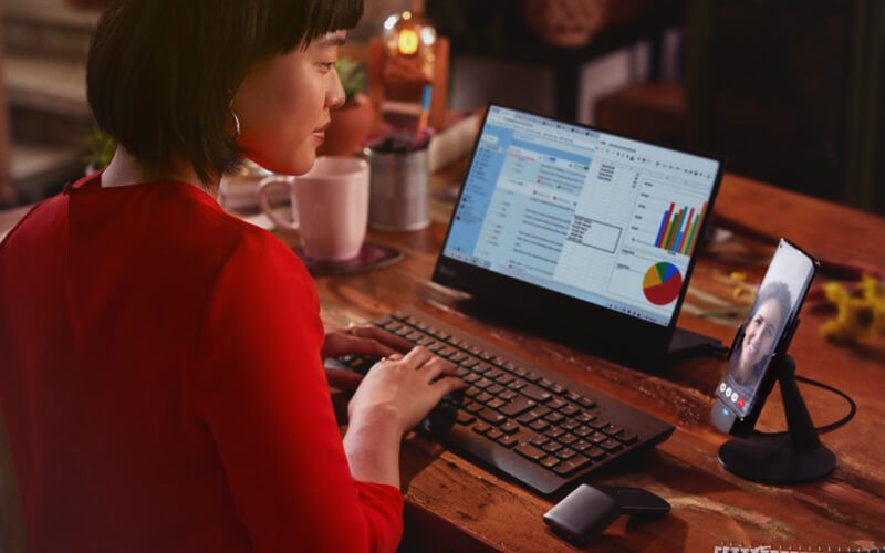 Woman using her laptop and Thinkphone