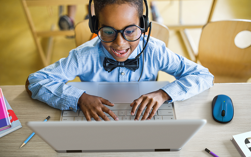 A happy kid using Chromebook laptop