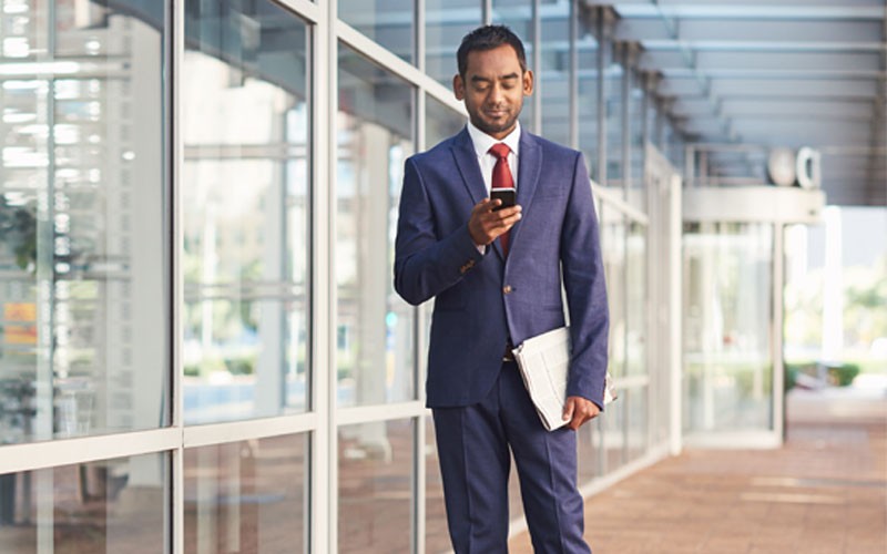 Business man using mobile device outside