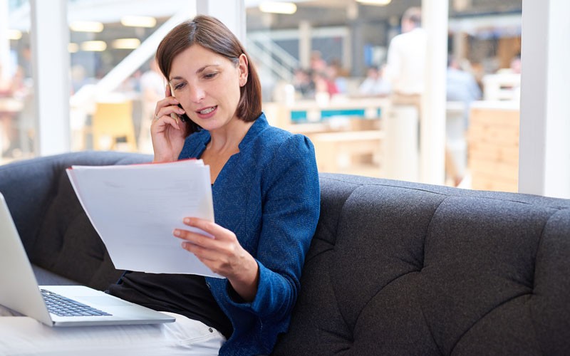 Woman reading in office using laptop