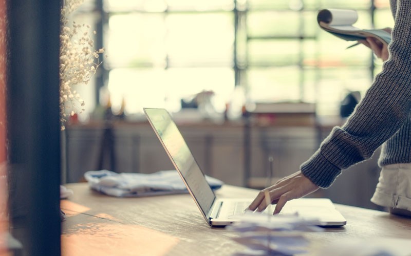 Woman clicking button on laptop