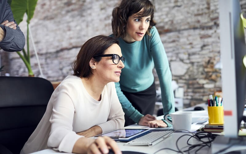 Two businesswomen on desktop computer