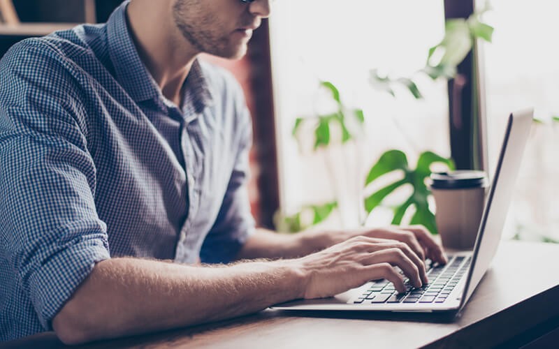 Close up of businessman on laptop computer in cafe