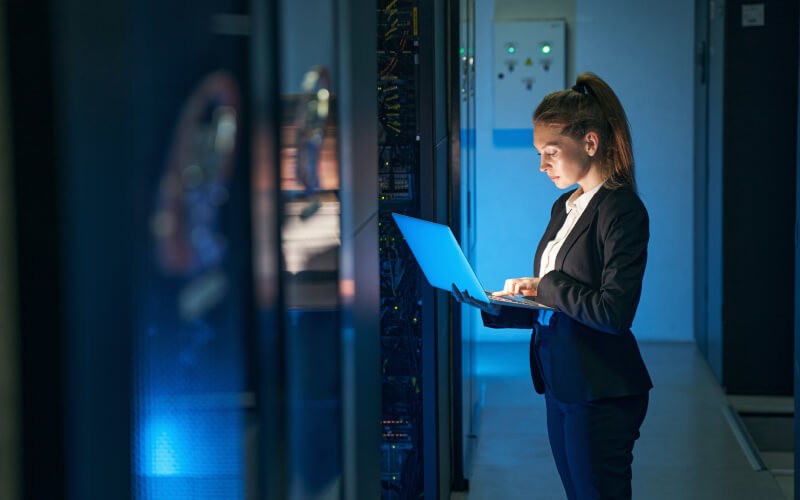 Woman standing holding her laptop