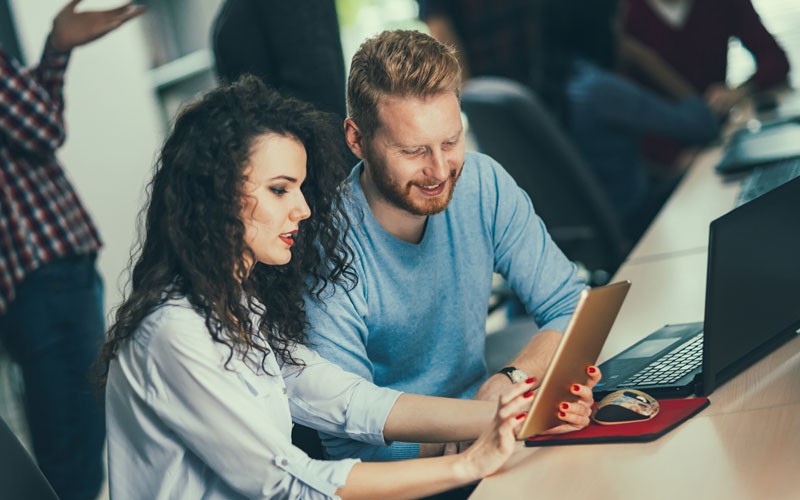 Two teammates collaborating at desk