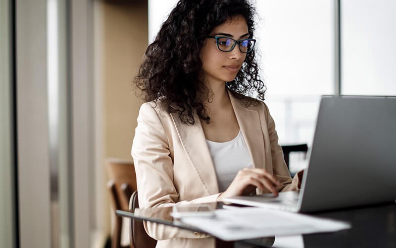 Business professional scanning documents on laptop computer