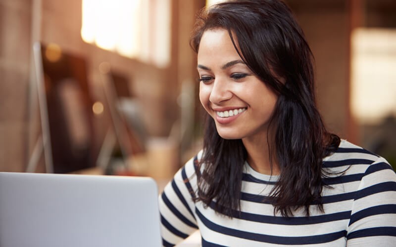 Business woman smiling at computer. Software license management. Software licensing solutions